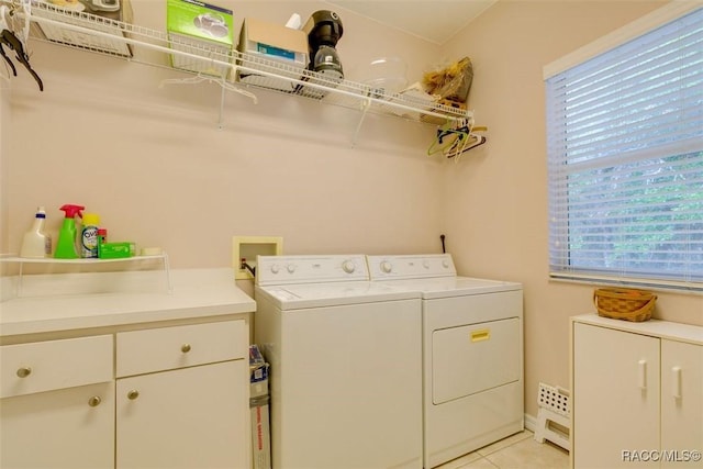 washroom featuring cabinets, light tile patterned floors, and washer and clothes dryer