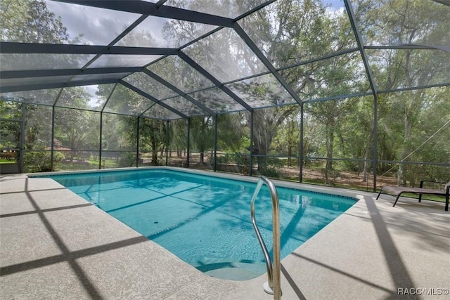 view of swimming pool featuring a patio and glass enclosure