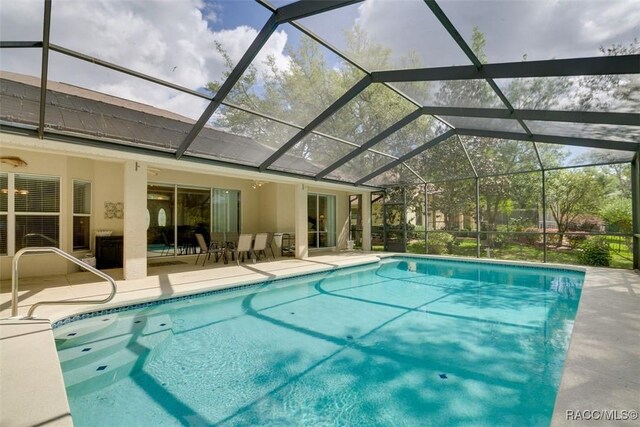 view of pool featuring a patio and glass enclosure