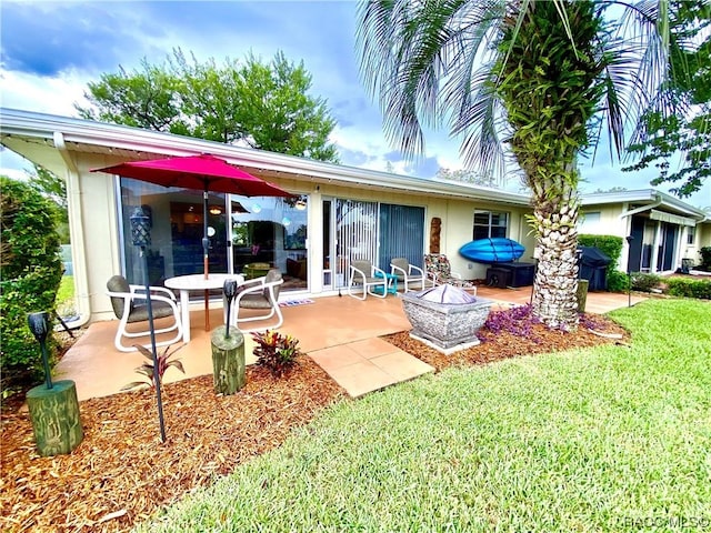 rear view of property featuring a patio area and a yard