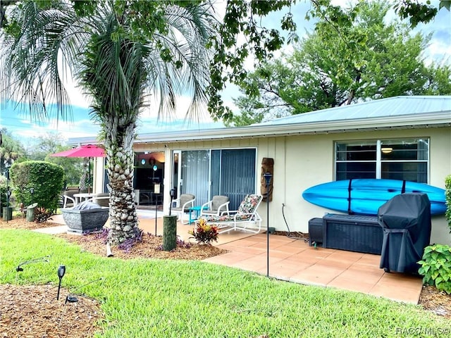 back of house featuring a lawn and a patio