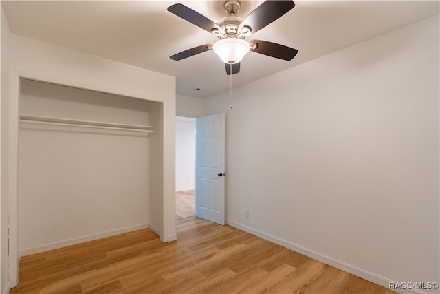 unfurnished bedroom with a closet, light hardwood / wood-style floors, and ceiling fan