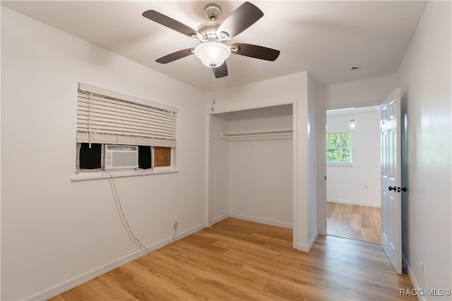 unfurnished bedroom featuring cooling unit, ceiling fan, light hardwood / wood-style floors, and a closet