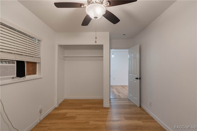 unfurnished bedroom with a closet, light hardwood / wood-style flooring, ceiling fan, and cooling unit