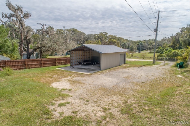 view of yard featuring a carport and an outbuilding