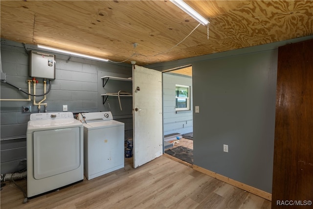 laundry room with washing machine and dryer and light wood-type flooring