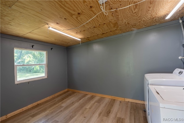 clothes washing area with light wood-type flooring, separate washer and dryer, and wood ceiling