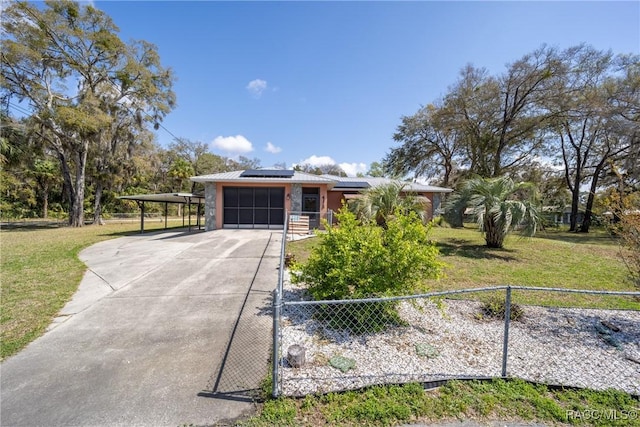 view of front facade featuring a front yard, a garage, driveway, solar panels, and fence