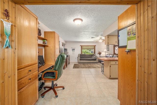 office featuring a ceiling fan, a textured ceiling, and light tile patterned flooring