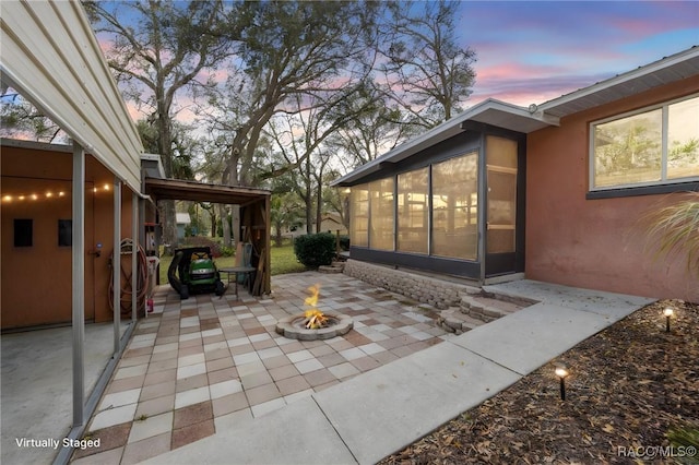 patio terrace at dusk featuring a fire pit