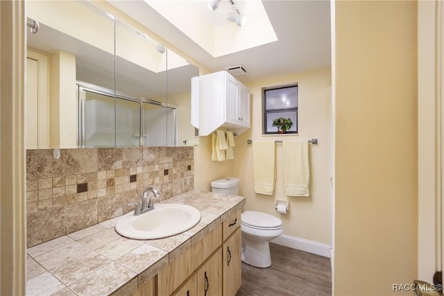 full bathroom featuring toilet, an enclosed shower, backsplash, baseboards, and wood finished floors