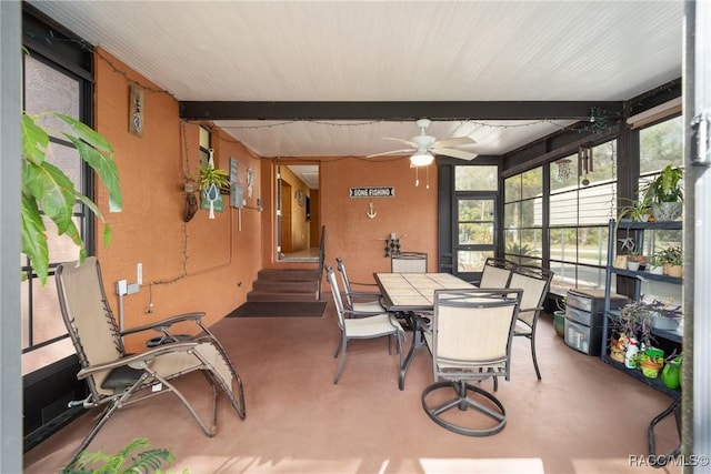 sunroom featuring entry steps, a ceiling fan, and beamed ceiling