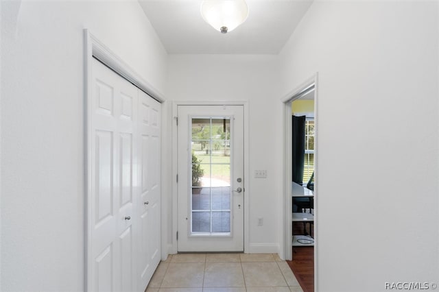 doorway to outside with light tile patterned floors