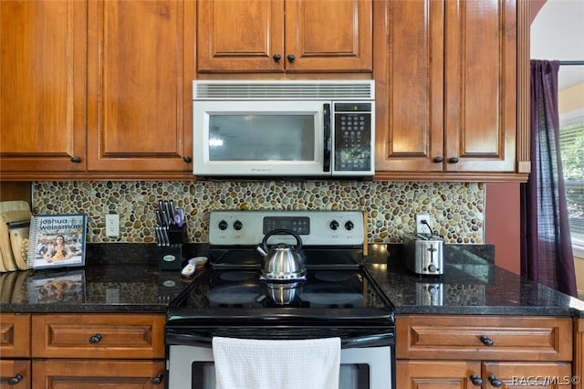 kitchen with tasteful backsplash, appliances with stainless steel finishes, and dark stone counters