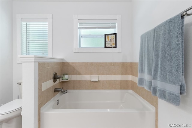 bathroom with a washtub and toilet