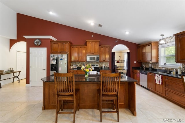 kitchen featuring a center island, light tile patterned floors, stainless steel appliances, and sink