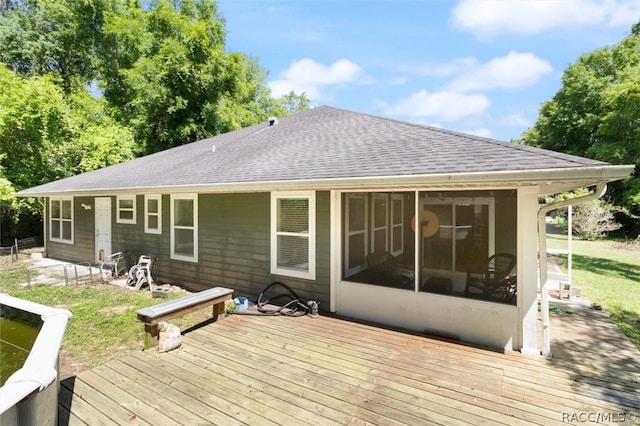 deck with a sunroom and a yard