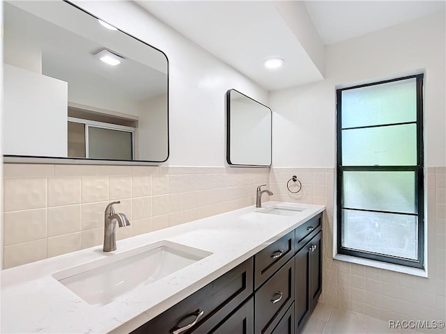 bathroom with vanity and tile walls