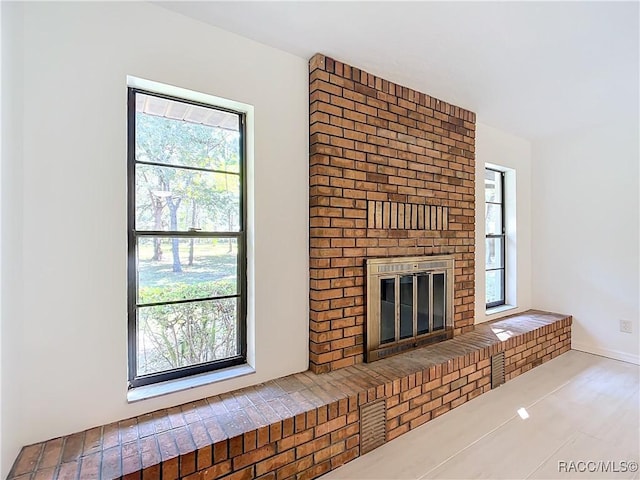 unfurnished living room with a brick fireplace