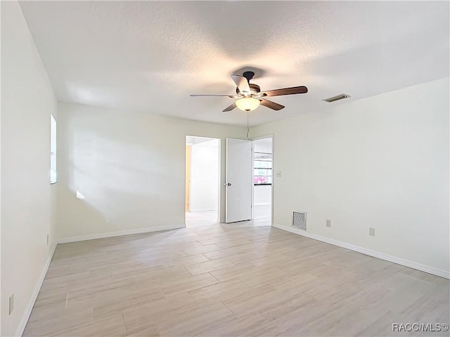 unfurnished room with ceiling fan and a textured ceiling