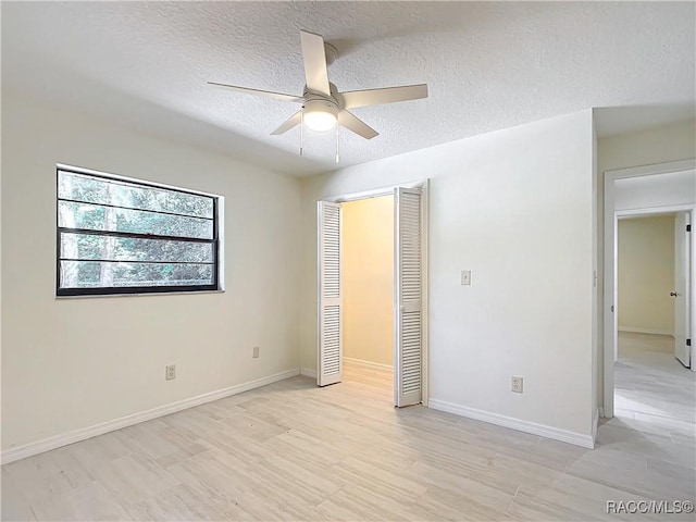 unfurnished bedroom with ceiling fan, a closet, and a textured ceiling