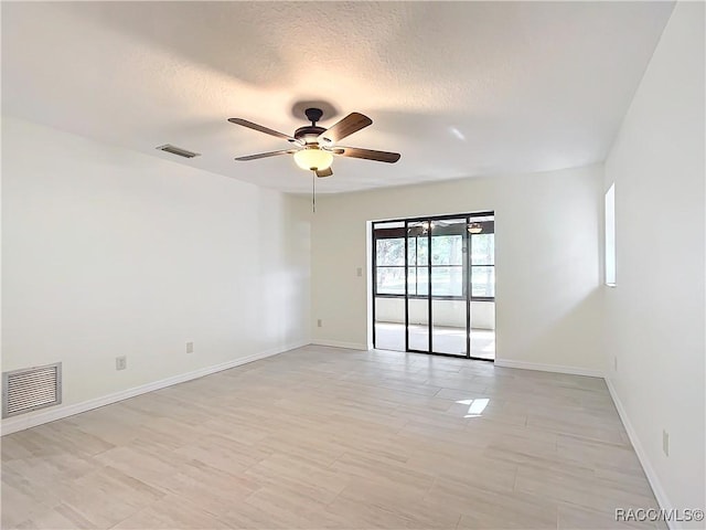 spare room with a textured ceiling and ceiling fan