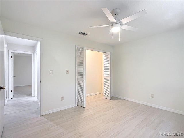 unfurnished bedroom with ceiling fan and a closet