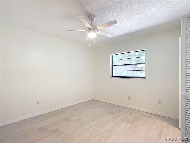 empty room featuring ceiling fan, a textured ceiling, and light wood-type flooring