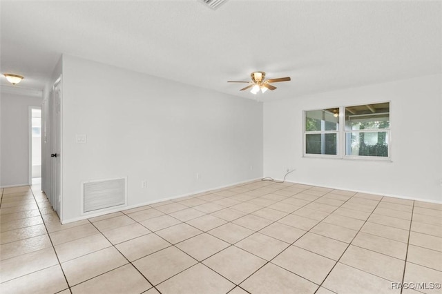 tiled spare room with ceiling fan