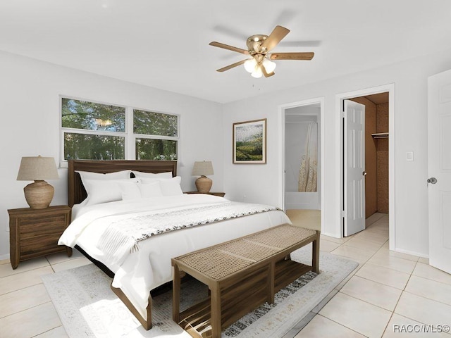 tiled bedroom with a spacious closet and ceiling fan