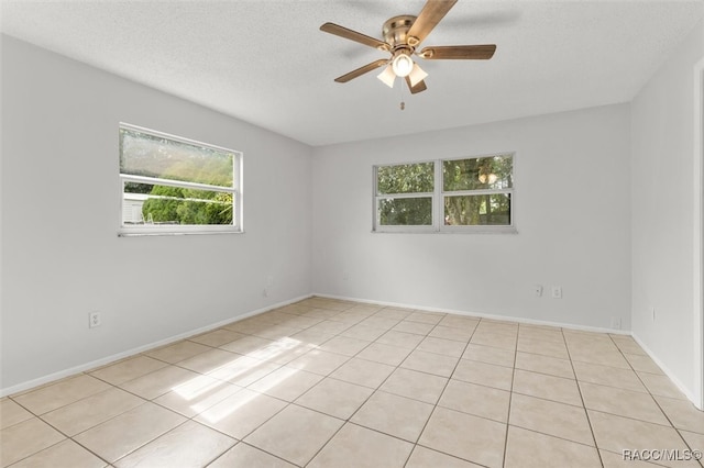 empty room featuring light tile patterned flooring, ceiling fan, and a textured ceiling