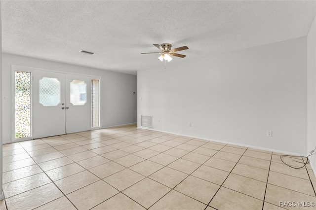 entrance foyer with light tile patterned floors, french doors, a textured ceiling, and ceiling fan