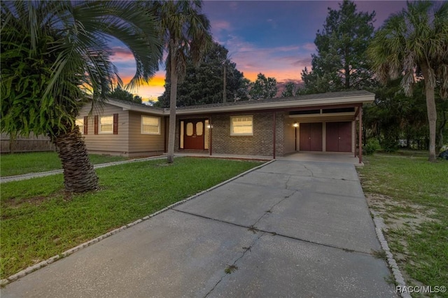 ranch-style house with a carport and a lawn