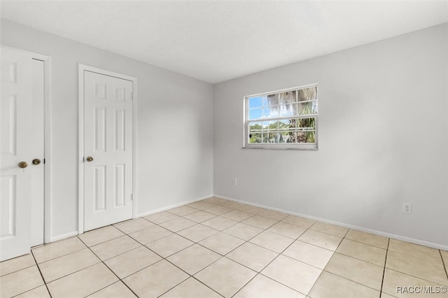 interior space featuring light tile patterned flooring and a textured ceiling