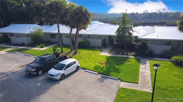 view of front of home with a front yard and a water view