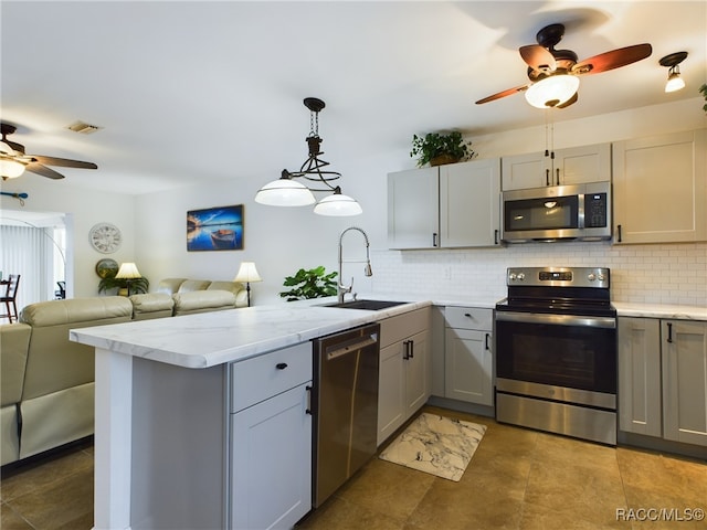 kitchen featuring sink, gray cabinets, kitchen peninsula, and appliances with stainless steel finishes