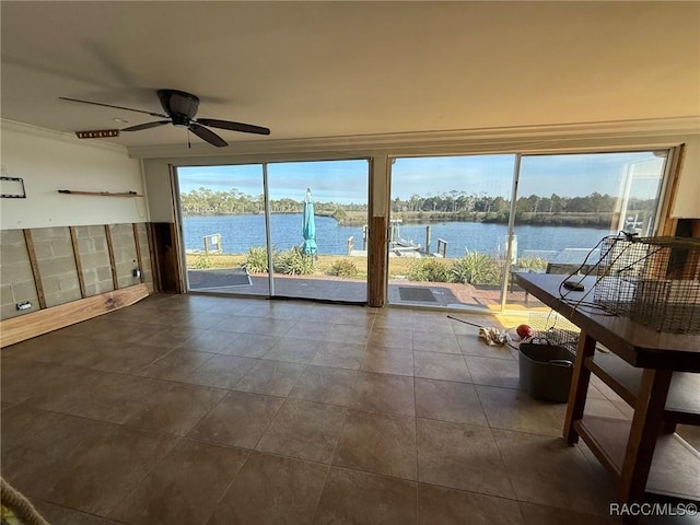 unfurnished sunroom featuring a water view, ceiling fan, and a healthy amount of sunlight