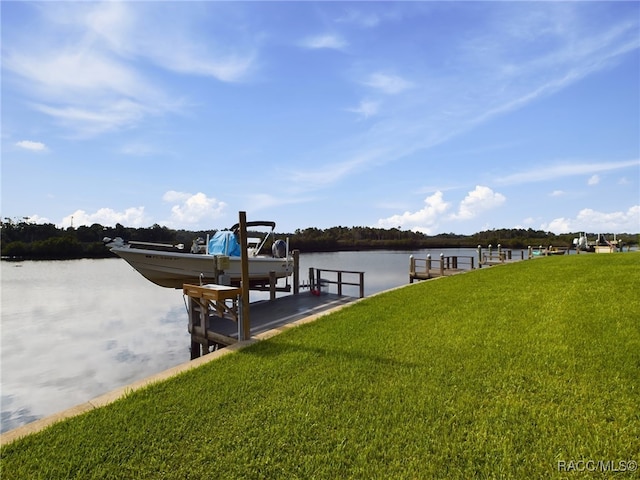 dock area with a water view and a lawn