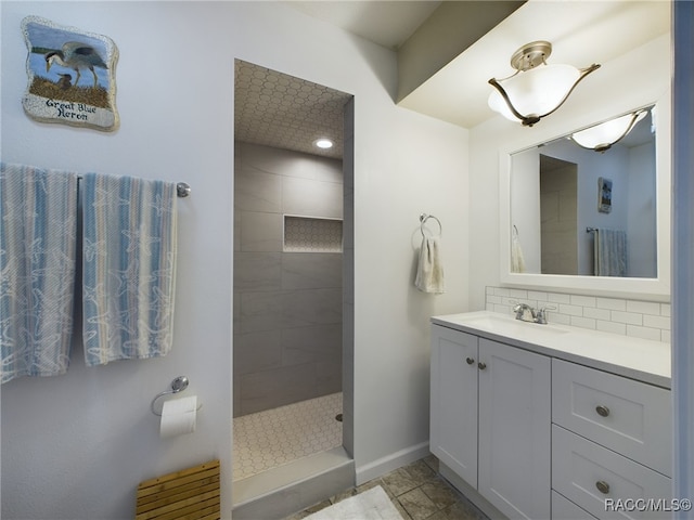 bathroom featuring vanity, decorative backsplash, and a tile shower