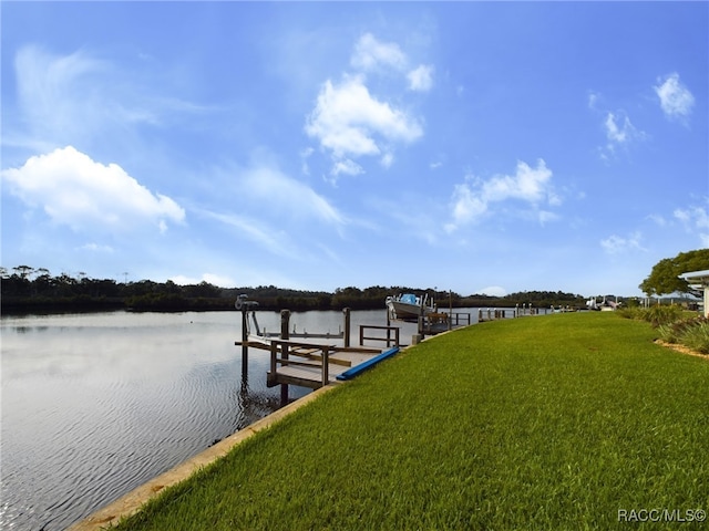 view of dock with a yard and a water view