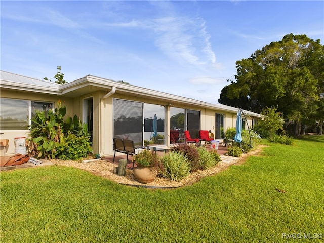 back of property featuring a yard and a patio area