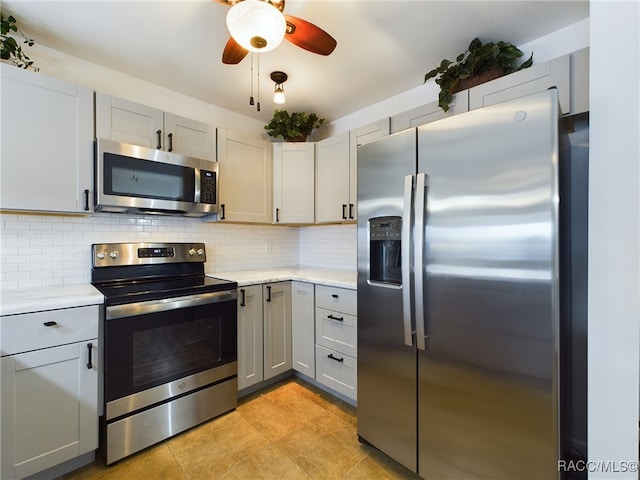 kitchen with ceiling fan, stainless steel appliances, gray cabinets, and decorative backsplash