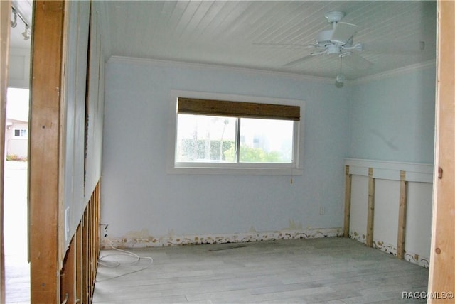 empty room featuring ceiling fan and crown molding