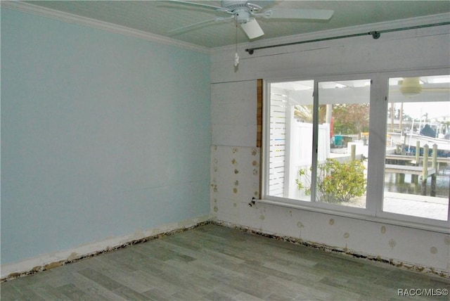 empty room with ceiling fan, crown molding, a water view, and light hardwood / wood-style flooring