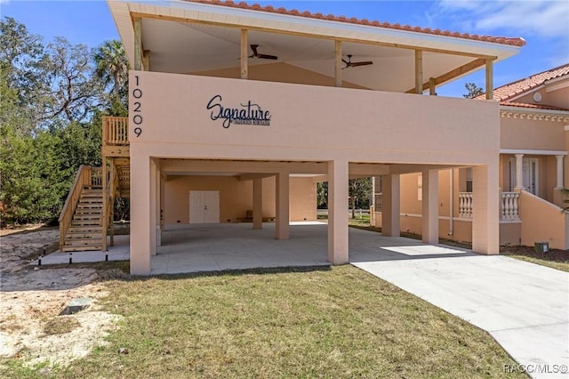 back of house with ceiling fan and a yard