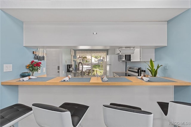 kitchen with a peninsula, a sink, and appliances with stainless steel finishes