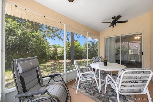 sunroom / solarium with ceiling fan and outdoor dining space