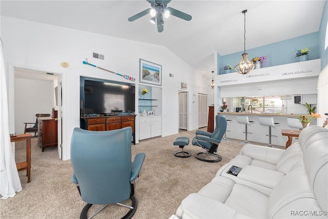living room featuring carpet floors, high vaulted ceiling, visible vents, and ceiling fan with notable chandelier