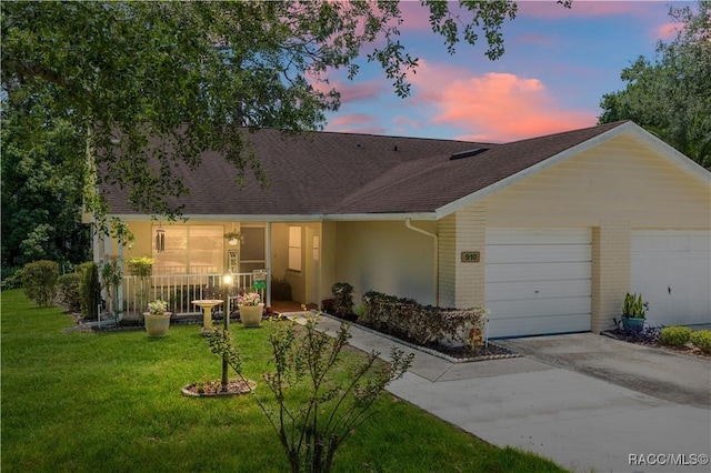 single story home with a garage, a front lawn, roof with shingles, stucco siding, and concrete driveway