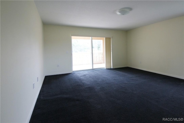 unfurnished room featuring dark colored carpet